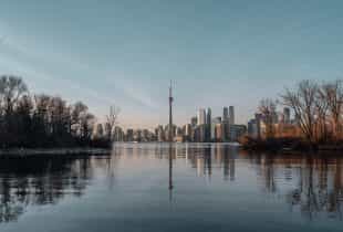 Die Skyline der Stadt Toronto in der kanadischen Provinz Ontario vor einem See