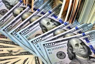 Zahlreiche 100-US-Dollar-Scheine über- und nebeneinander.