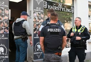 Polizeibeamte durchsuchen ein Hinterzimmer eines Friseursalons, wo eine illegale Pokerrunde stattfand.