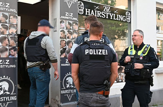Polizeibeamte durchsuchen ein Hinterzimmer eines Friseursalons, wo eine illegale Pokerrunde stattfand.