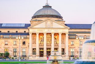 Der prunkvolle neoklassizistische Eingang des Kurhauses in Wiesbaden bei Tag, in dem sich die historische Spielbank befindet.