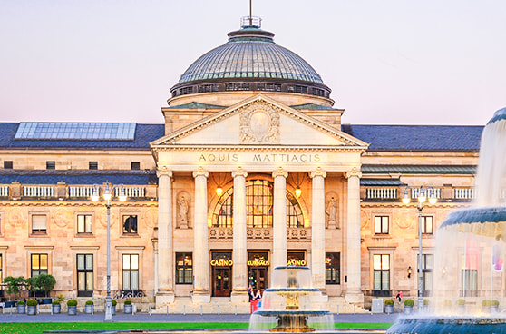 Der prunkvolle neoklassizistische Eingang des Kurhauses in Wiesbaden bei Tag, in dem sich die historische Spielbank befindet.